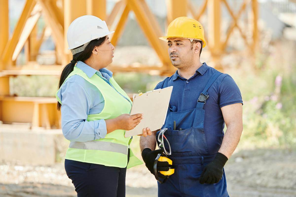 Two construction workers having a conversation on a job site.